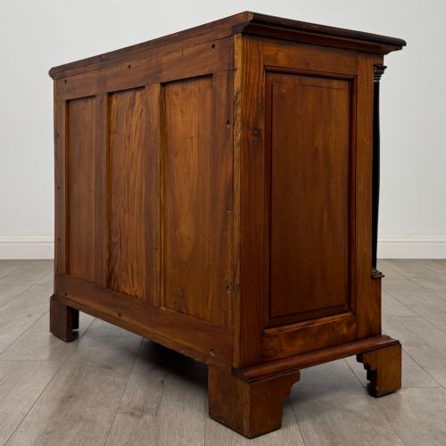fig 5. A 20th-century Georgian style mahogany chest featuring four full-width drawers with brass drop handles, flanked by ebonised side columns, resting on bracket feet.