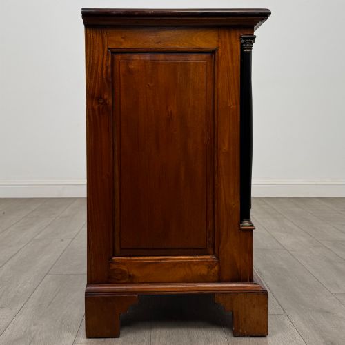 fig 6. A 20th-century Georgian style mahogany chest featuring four full-width drawers with brass drop handles, flanked by ebonised side columns, resting on bracket feet.