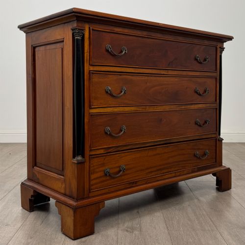 fig 7. A 20th-century Georgian style mahogany chest featuring four full-width drawers with brass drop handles, flanked by ebonised side columns, resting on bracket feet.