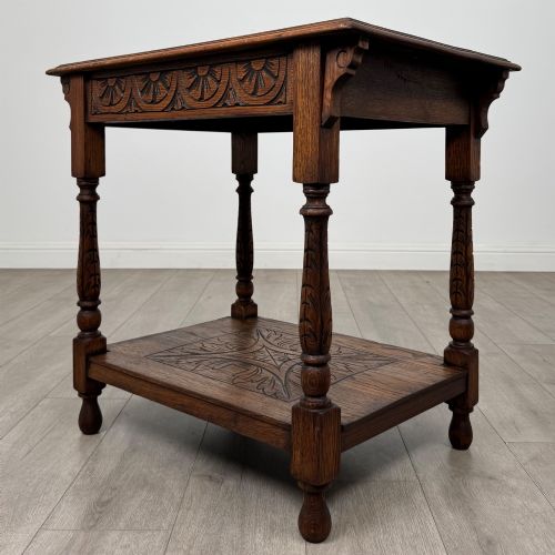 fig 5. An antique Edwardian carved oak side table featuring a carved apron, four turned legs, and a carved foliate motif on its lower shelf.