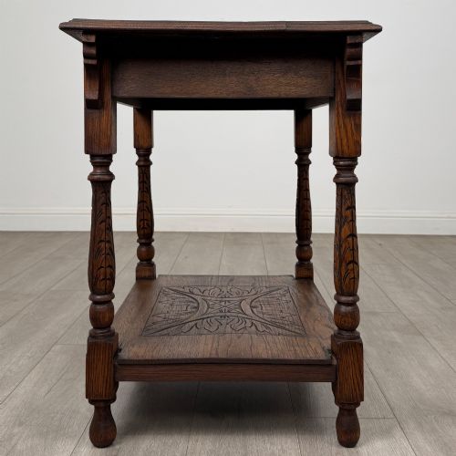 fig 6. An antique Edwardian carved oak side table featuring a carved apron, four turned legs, and a carved foliate motif on its lower shelf.