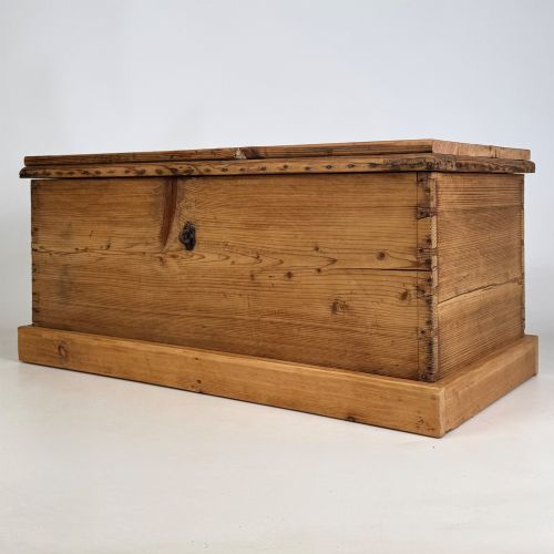fig 1. A nineteenth-century Victorian pine blanket box featuring a flat hinged lid, central iron keyhole escutcheon, visible corner joinery, and a solid plinth base.