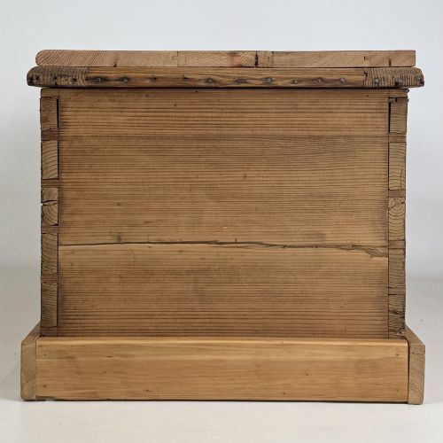 fig 2. A nineteenth-century Victorian pine blanket box featuring a flat hinged lid, central iron keyhole escutcheon, visible corner joinery, and a solid plinth base.