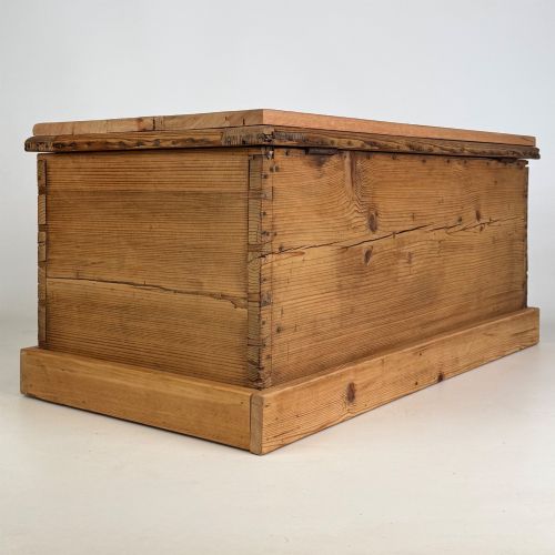 fig 3. A nineteenth-century Victorian pine blanket box featuring a flat hinged lid, central iron keyhole escutcheon, visible corner joinery, and a solid plinth base.