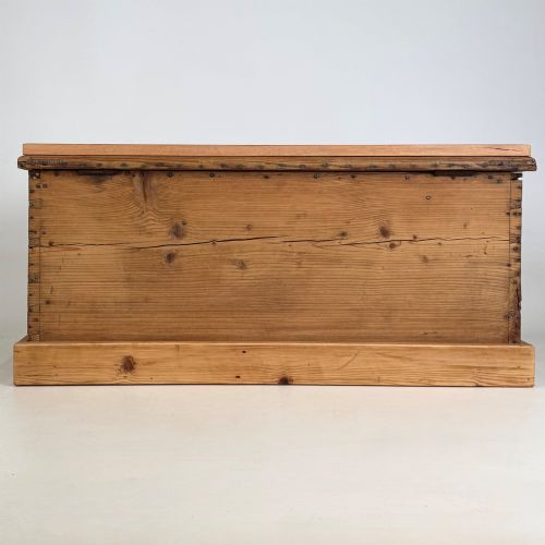 fig 4. A nineteenth-century Victorian pine blanket box featuring a flat hinged lid, central iron keyhole escutcheon, visible corner joinery, and a solid plinth base.