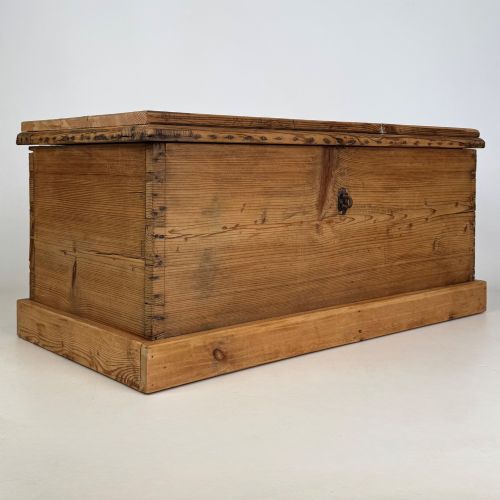 fig 7. A nineteenth-century Victorian pine blanket box featuring a flat hinged lid, central iron keyhole escutcheon, visible corner joinery, and a solid plinth base.