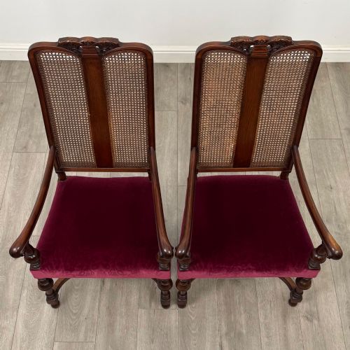 fig 7. A set of mahogany dining chairs featuring high cane-panelled backs, carved top crests, turned legs, and deep red velvet seats.
