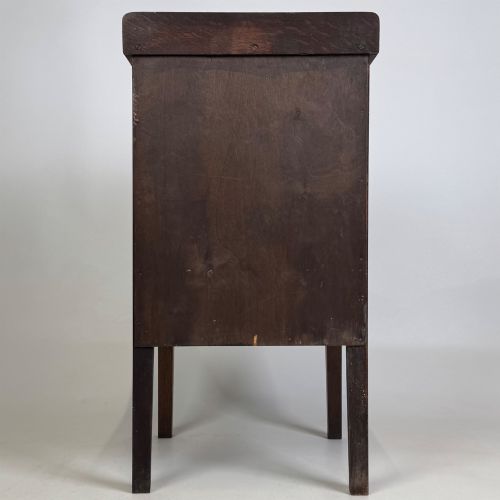 fig 5. An Edwardian dark brown oak cabinet featuring a single panelled door with a round wooden knob supported on four square straight legs.