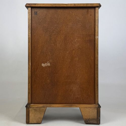 fig 4. A small mahogany open bookcase featuring a single top drawer with brass swan-neck handles, satinwood inlay, open lower shelving, and shaped bracket feet.