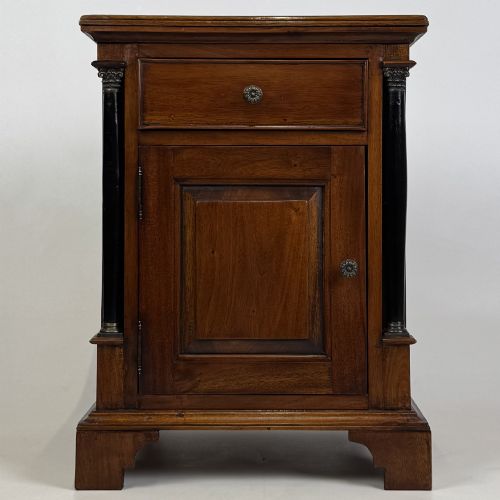 fig 1. A pair of matching mahogany bedside cabinets with single top drawers, panelled cupboard doors, and black ebonised side columns.