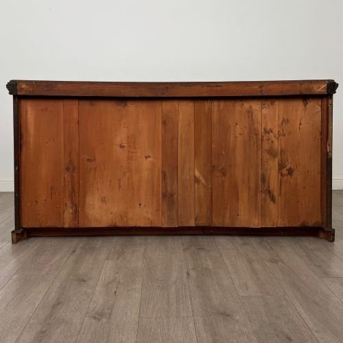 fig 5. A wide 19th-century Victorian dark oak sideboard featuring relief-carved floral panels, central drawers with brass handles, and lower cupboard doors.