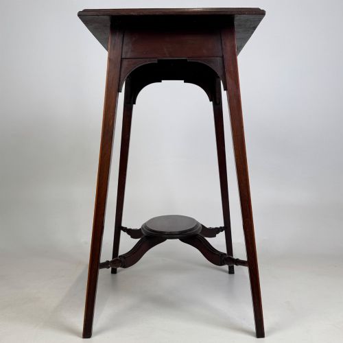 fig 2. An Edwardian mahogany side table featuring a square top, splayed legs, corner spandrels, and a central circular undertier supported by shaped stretchers.