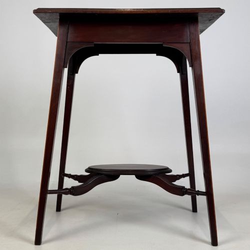 fig 4. An Edwardian mahogany side table featuring a square top, splayed legs, corner spandrels, and a central circular undertier supported by shaped stretchers.