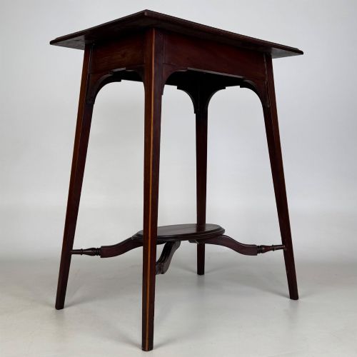 fig 7. An Edwardian mahogany side table featuring a square top, splayed legs, corner spandrels, and a central circular undertier supported by shaped stretchers.