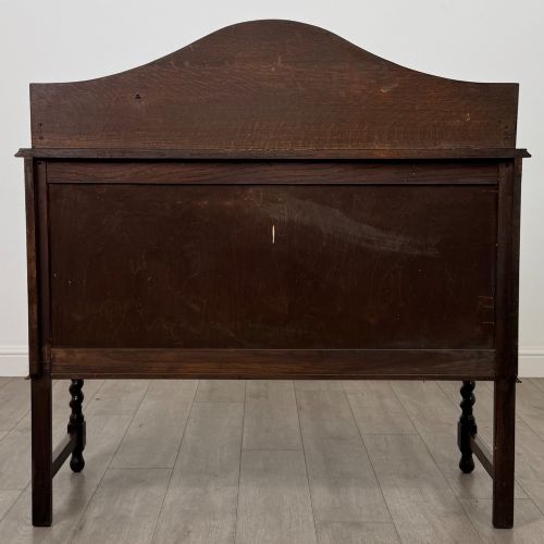 fig 5. An Edwardian dark oak sideboard featuring a shaped upstand gallery, two top drawers with brass drop handles, twin raised-panel cupboard doors, and front barley twist legs.
