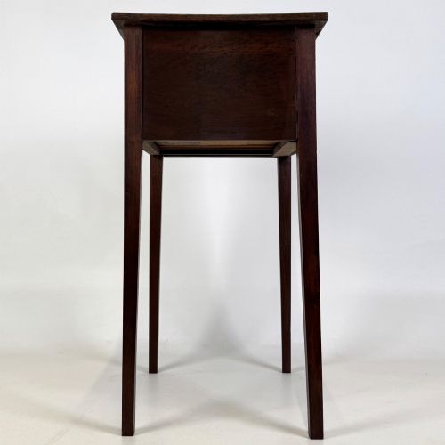 fig 2. An antique dark mahogany side table featuring two stacked drawers with circular handles, supported by tall tapered square legs.