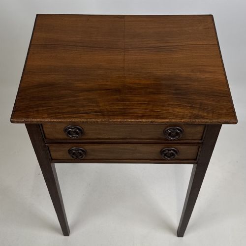 fig 8. An antique dark mahogany side table featuring two stacked drawers with circular handles, supported by tall tapered square legs.