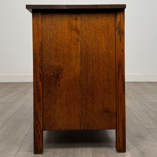 fig 2. An antique Arts and Crafts oak chest of drawers featuring two short drawers over two full-width drawers with iron drop-ring handles on square backplates.