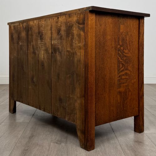 fig 5. An antique Arts and Crafts oak chest of drawers featuring two short drawers over two full-width drawers with iron drop-ring handles on square backplates.