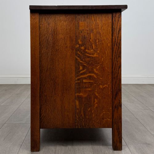 fig 6. An antique Arts and Crafts oak chest of drawers featuring two short drawers over two full-width drawers with iron drop-ring handles on square backplates.