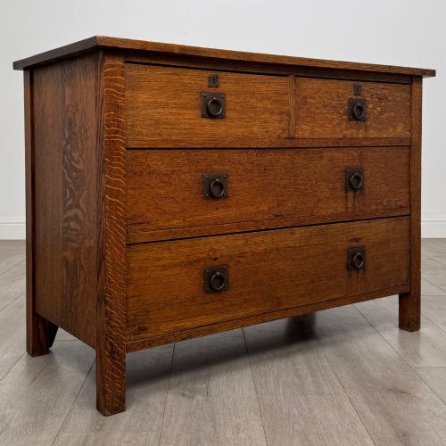 fig 7. An antique Arts and Crafts oak chest of drawers featuring two short drawers over two full-width drawers with iron drop-ring handles on square backplates.
