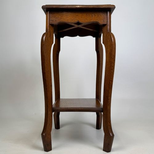 fig 2. An Edwardian oak side table featuring a rectangular top, shaped apron, flared legs, and a lower square tier.