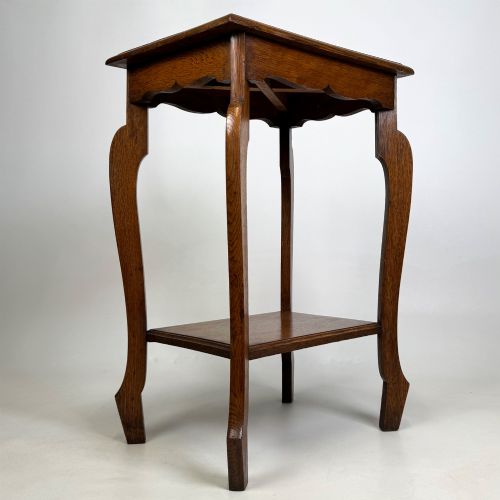 fig 3. An Edwardian oak side table featuring a rectangular top, shaped apron, flared legs, and a lower square tier.