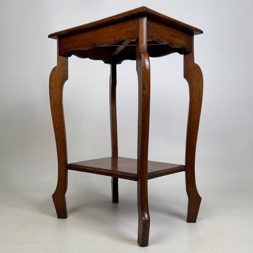fig 5. An Edwardian oak side table featuring a rectangular top, shaped apron, flared legs, and a lower square tier.
