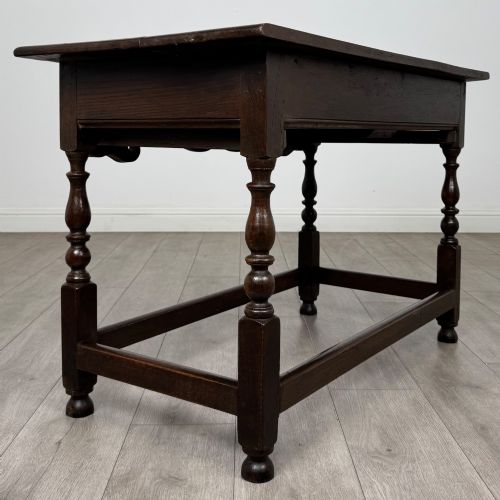 fig 3. An 18th-century dark oak Georgian side table featuring two frieze drawers with brass handles, turned legs, a shaped apron, and a lower box stretcher.