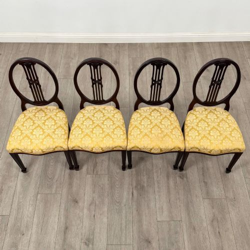 fig 6. A set of four dark mahogany dining chairs with carved oval backs, slender vertical splats, and gold damask upholstered seats.