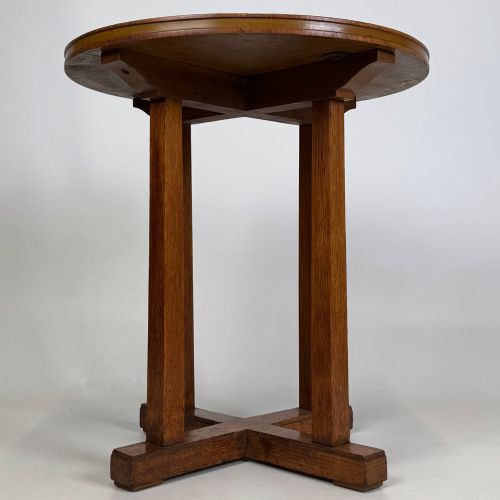 fig 4. An early twentieth-century round oak side table featuring a circular top supported by straight legs and an X-frame cross base.