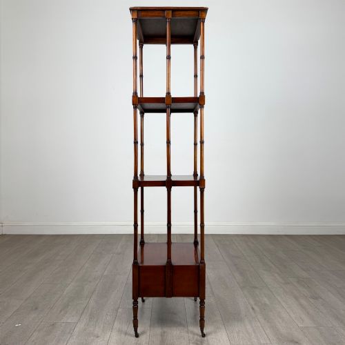 fig 6. A tall, narrow 20th-century mahogany open bookcase featuring four tiered shelves supported by turned columns and a single drawer at the base raised on brass castors.
