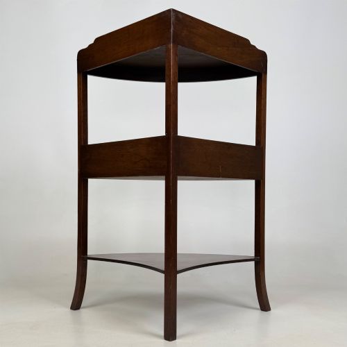 fig 2. A three-tiered Georgian style mahogany corner stand featuring a curved front, single drawer with brass ring pull, and splayed legs.