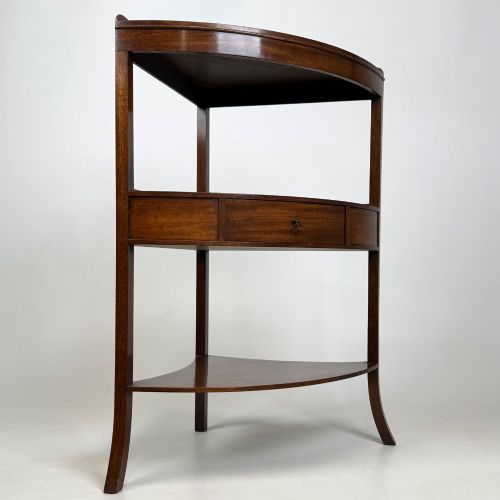 fig 3. A three-tiered Georgian style mahogany corner stand featuring a curved front, single drawer with brass ring pull, and splayed legs.