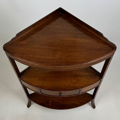 fig 4. A three-tiered Georgian style mahogany corner stand featuring a curved front, single drawer with brass ring pull, and splayed legs.