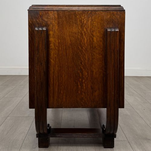 fig 3. An Art Deco oak desk featuring two side cupboard pedestals supported by u-shaped curved legs and a central drawer.