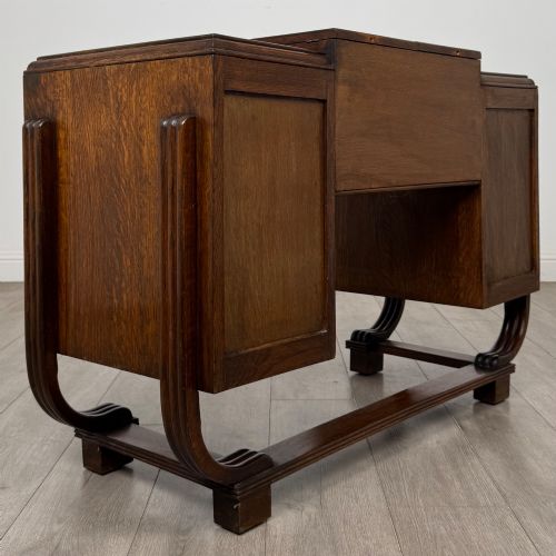 fig 4. An Art Deco oak desk featuring two side cupboard pedestals supported by u-shaped curved legs and a central drawer.