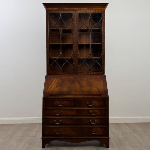fig 1. An antique mahogany bureau bookcase featuring two astragal glazed glass upper doors above a lower drop-front writing slope and four drawers.