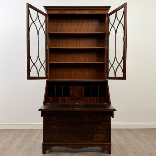fig 2. An antique mahogany bureau bookcase featuring two astragal glazed glass upper doors above a lower drop-front writing slope and four drawers.