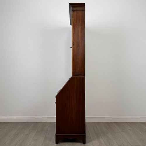 fig 4. An antique mahogany bureau bookcase featuring two astragal glazed glass upper doors above a lower drop-front writing slope and four drawers.