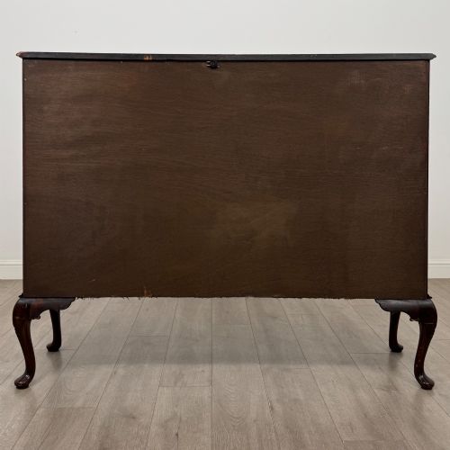 fig 5. An early twentieth-century mahogany display cabinet featuring three glazed doors with curved astragal glazing bars, a carved top frieze, green fabric interior, and cabriole legs.