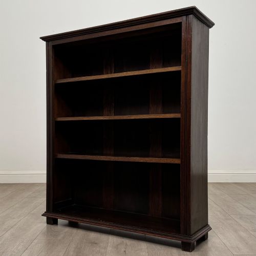 fig 2. An Edwardian open oak bookcase with four wide shelves and dark timber finish.