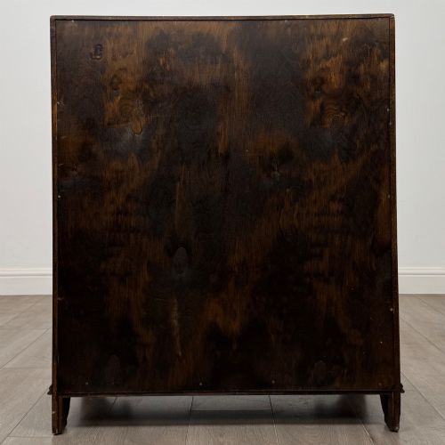 fig 5. A dark oak writing bureau with a slanted fall-front upper section featuring three carved linenfold panels above four drawers with turned wooden knob handles.