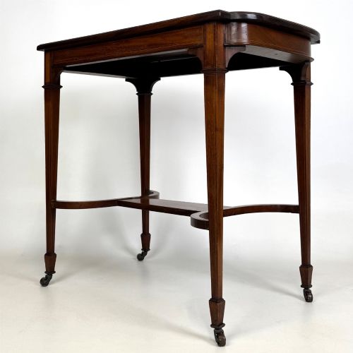 fig 1. An early 20th-century mahogany side table featuring fine boxwood inlay along the apron, tapered square legs on brass castors, and a curved lower stretcher.