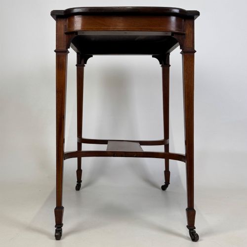 fig 2. An early 20th-century mahogany side table featuring fine boxwood inlay along the apron, tapered square legs on brass castors, and a curved lower stretcher.