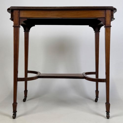 fig 4. An early 20th-century mahogany side table featuring fine boxwood inlay along the apron, tapered square legs on brass castors, and a curved lower stretcher.