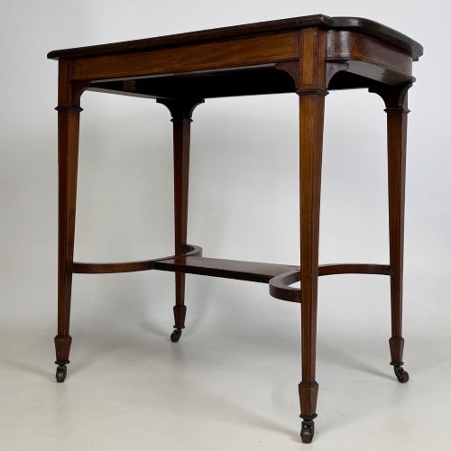 fig 5. An early 20th-century mahogany side table featuring fine boxwood inlay along the apron, tapered square legs on brass castors, and a curved lower stretcher.