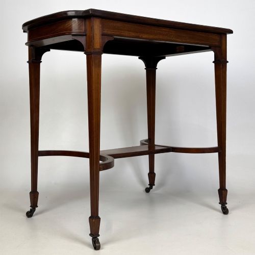 fig 7. An early 20th-century mahogany side table featuring fine boxwood inlay along the apron, tapered square legs on brass castors, and a curved lower stretcher.