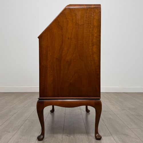 fig 3. An Edwardian figured walnut writing bureau featuring a slant front above three drawers and carved cabriole legs.