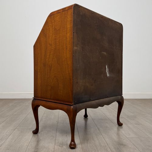 fig 4. An Edwardian figured walnut writing bureau featuring a slant front above three drawers and carved cabriole legs.